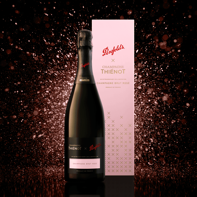 Black champagne Rose bottle and pale pink gift box.  Pink sparkles sit behind the bottle.